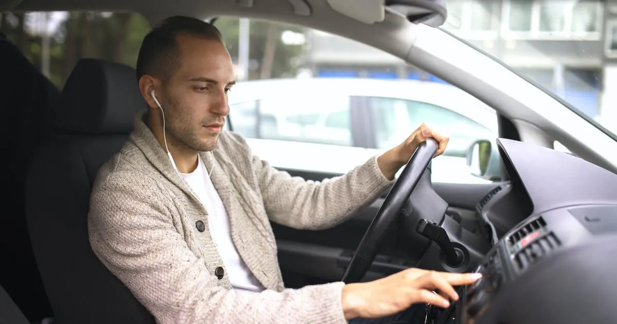a person with headphones changing music in the car
