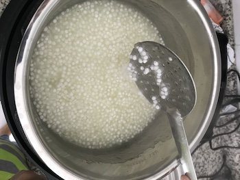 Tapioca pearls in a cooker with a ladle