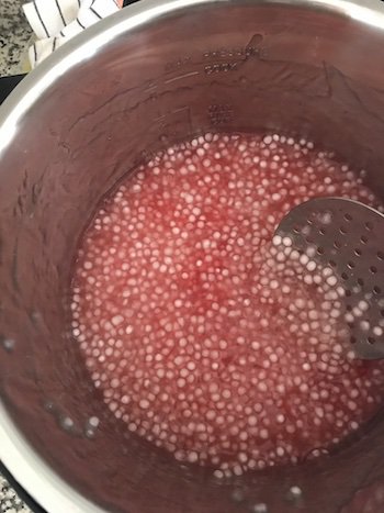 Tapioca pearls with red food colouring in a cooker