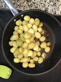 adding boiled potatoes in a pan