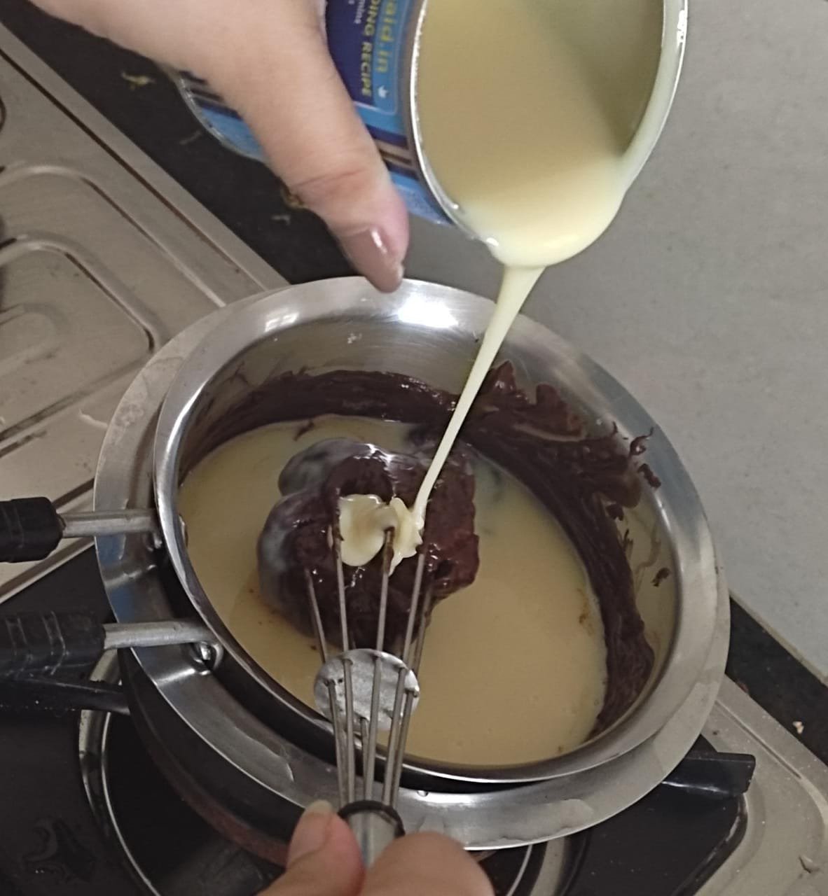 Adding condensed milk to melted dark chocolate