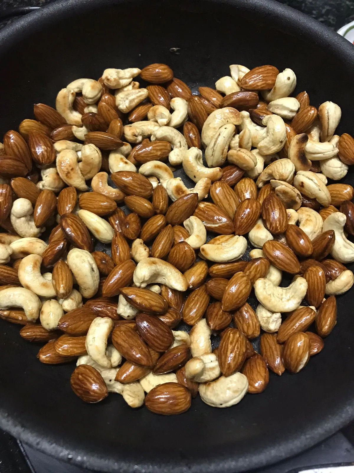 almonds and cashew getting roasted in a pan with ghee
