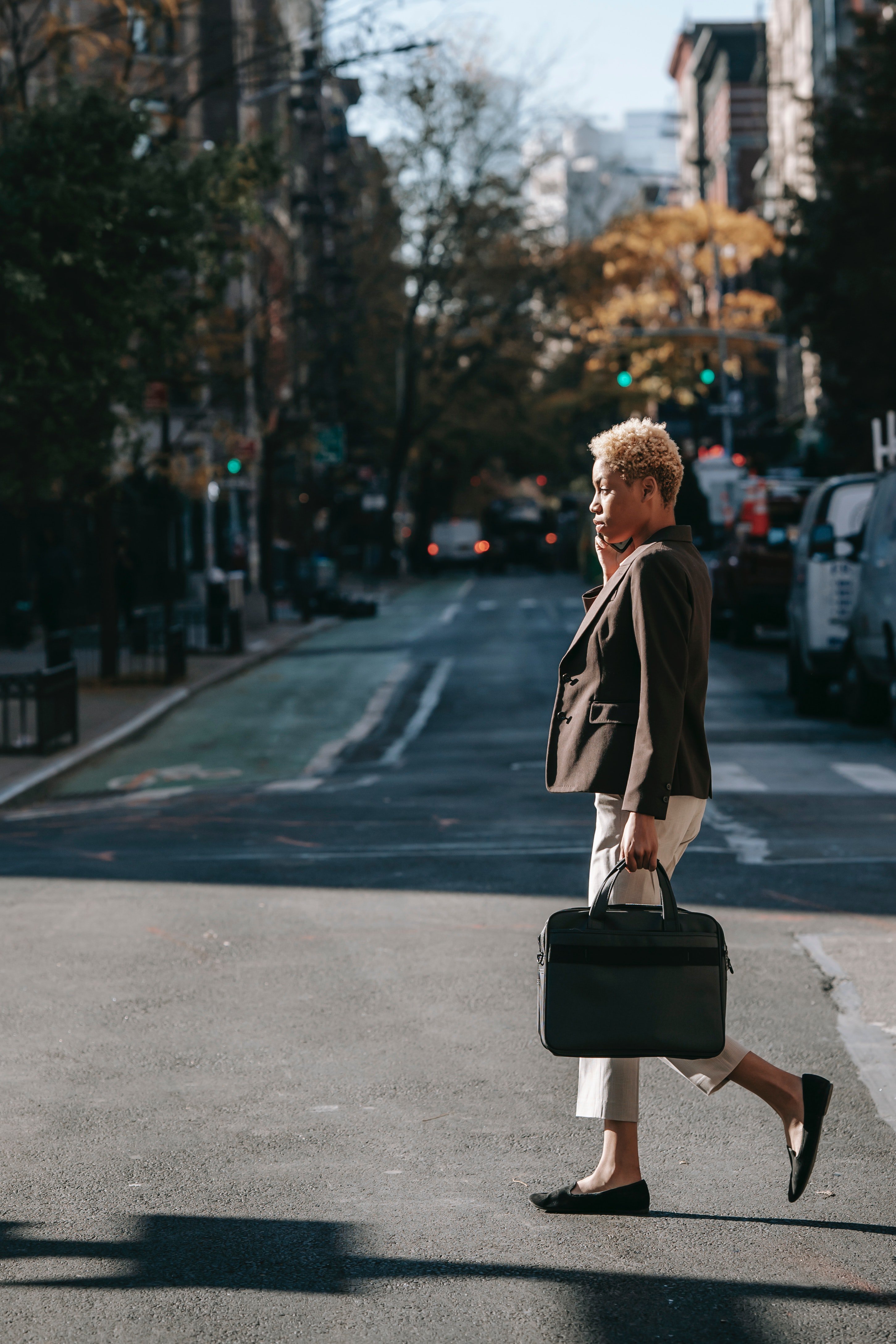 a well dressed woman carrying a laptop case