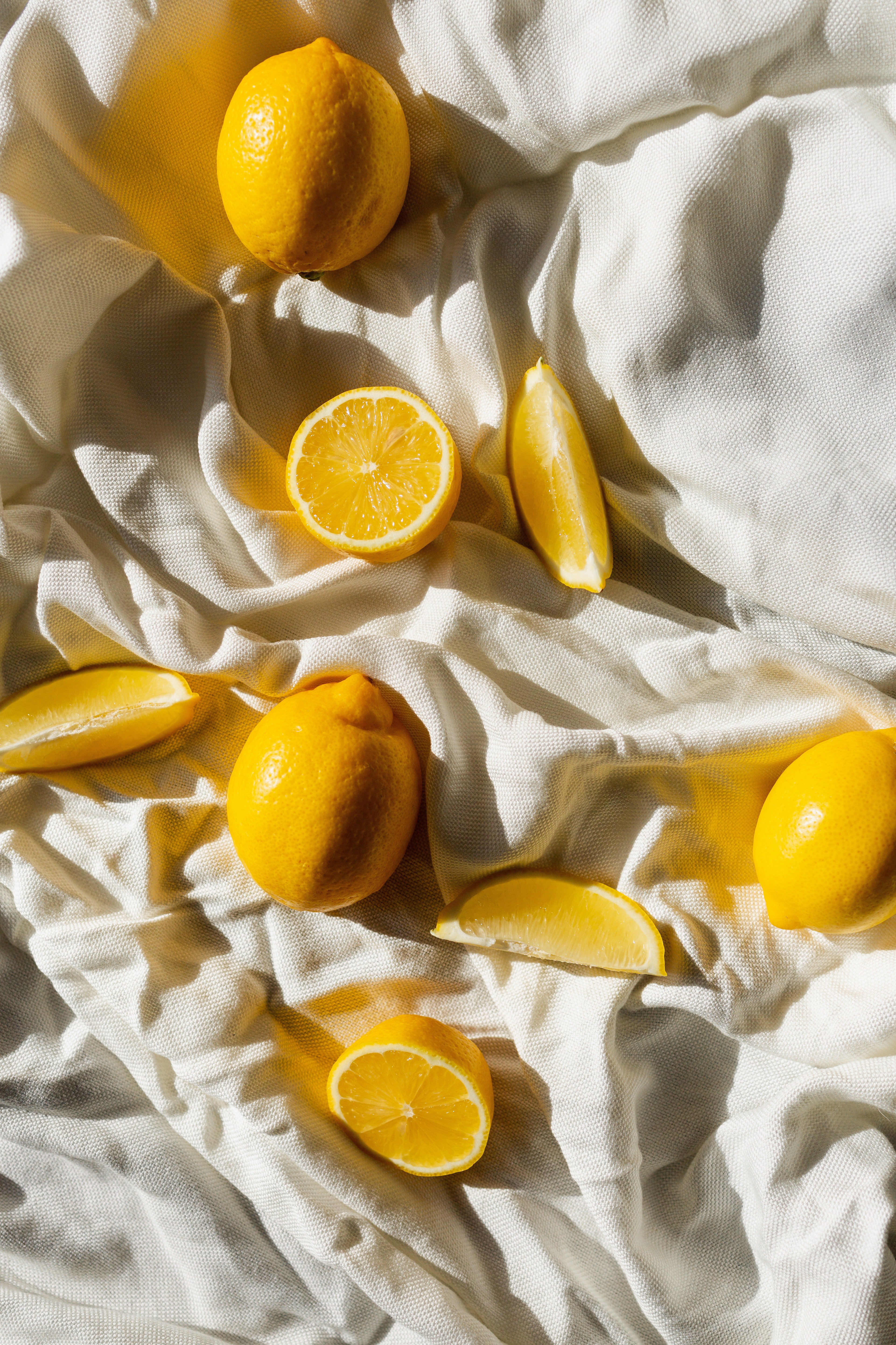 Whole lemons and lemon slices on a white cloth