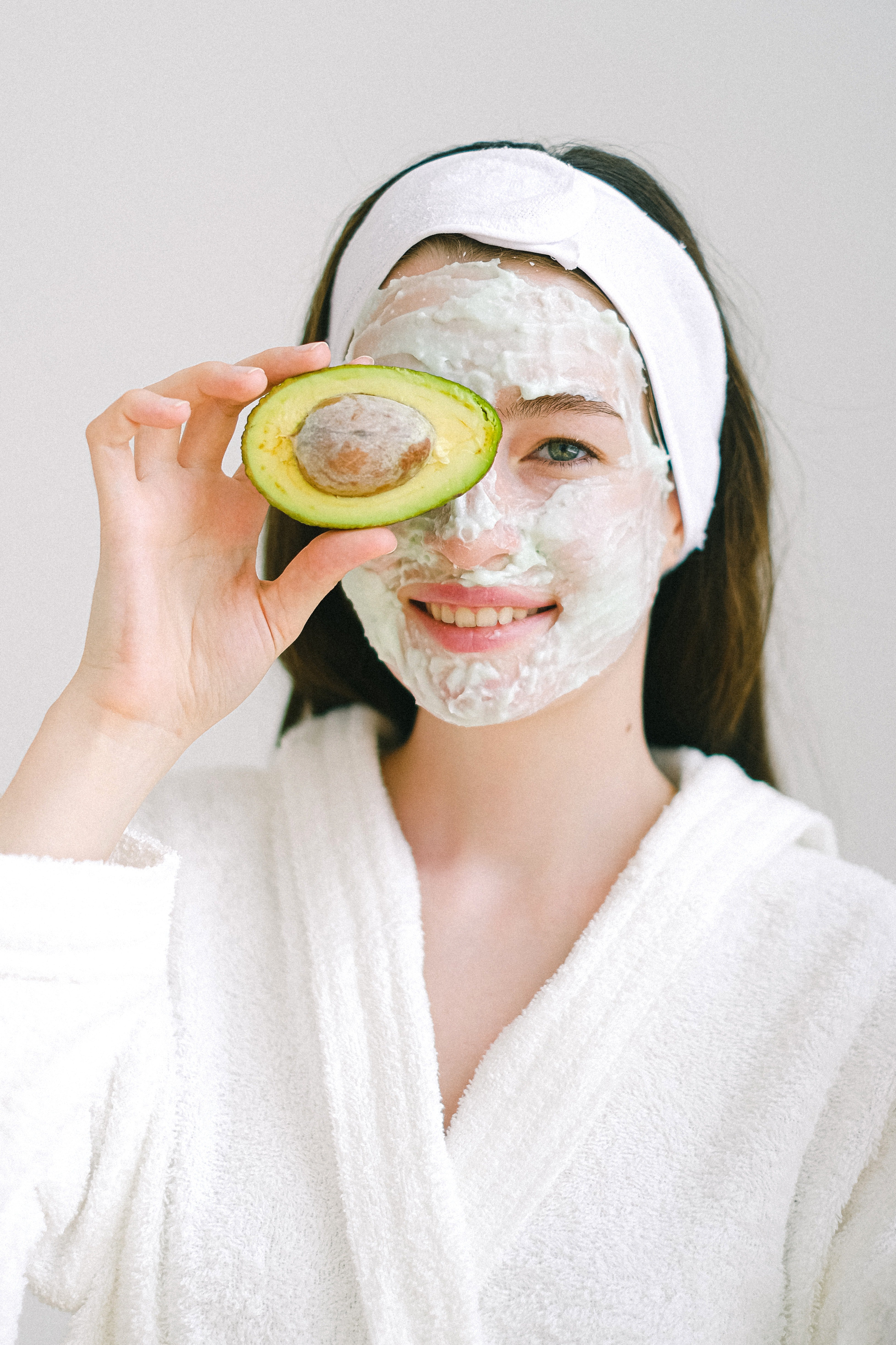 a lady with a face mask holding an avacado