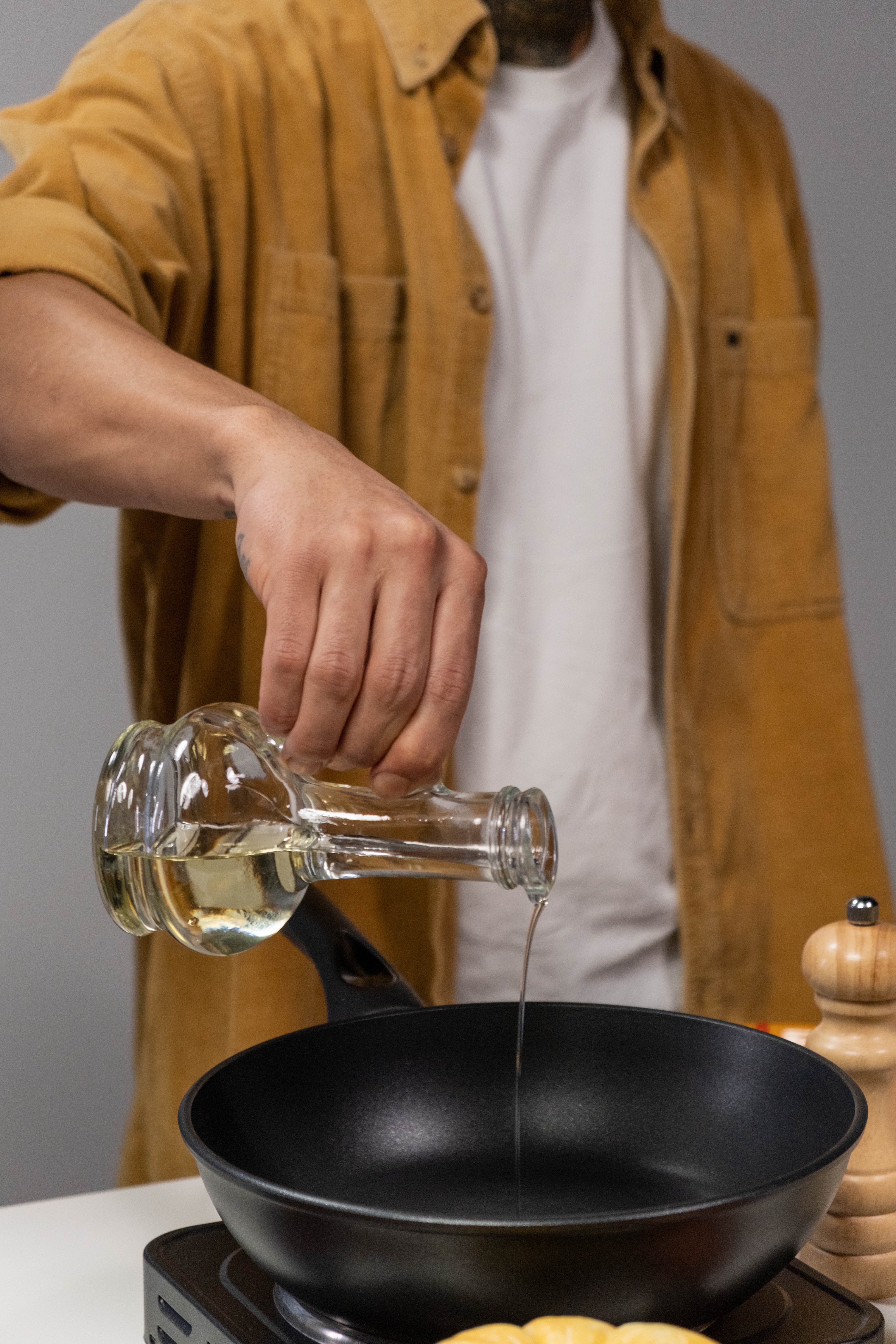 A man putting oil in a pan