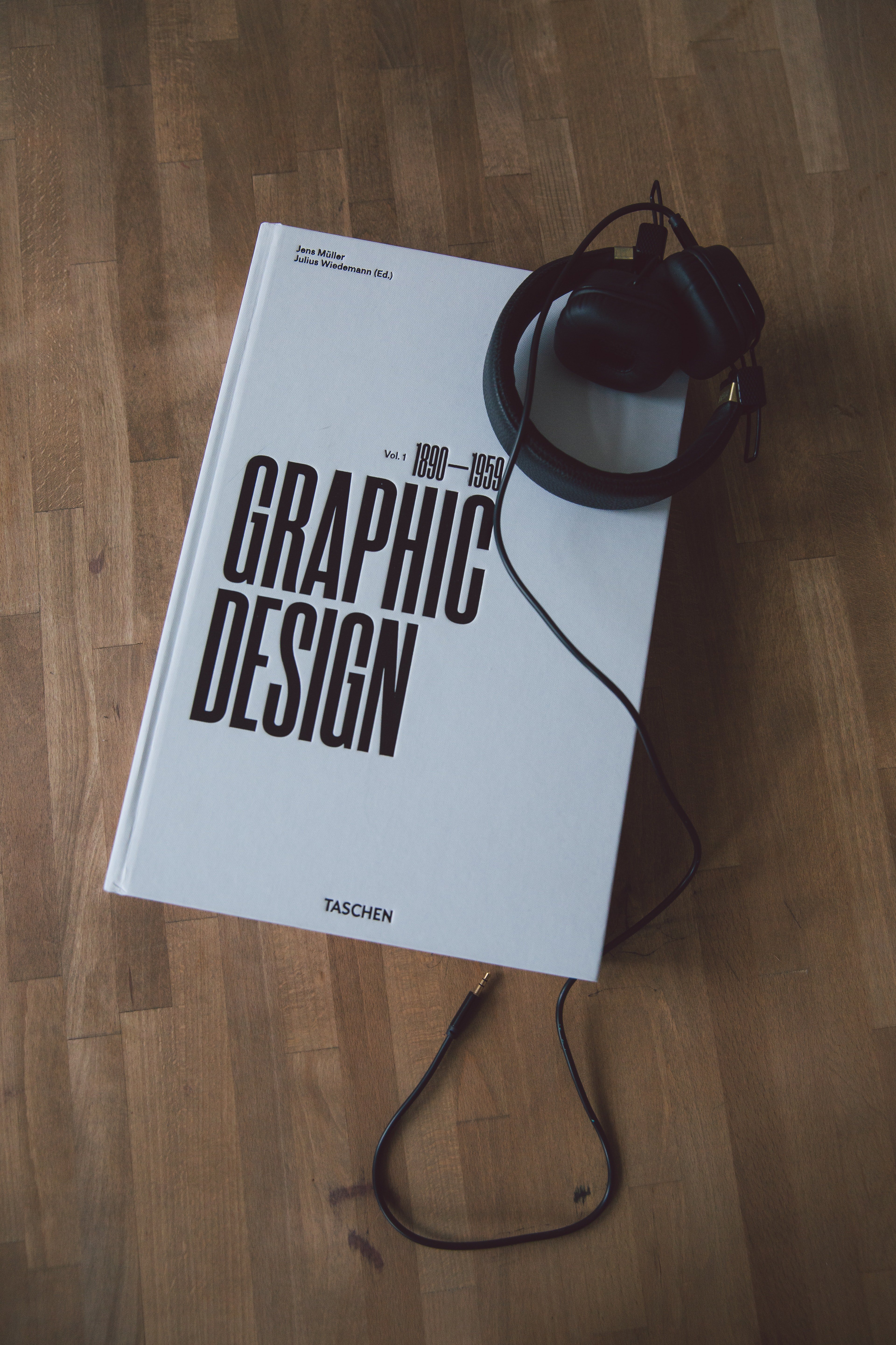 A journal with graphic design written on it with headphones on top