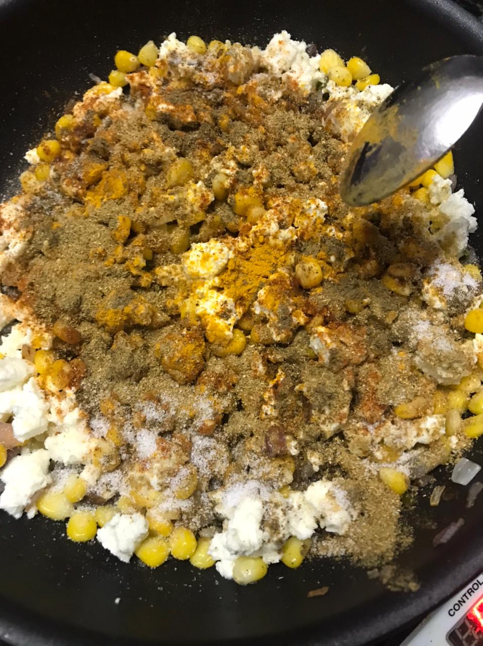 Spices added to the bhurji in a pan