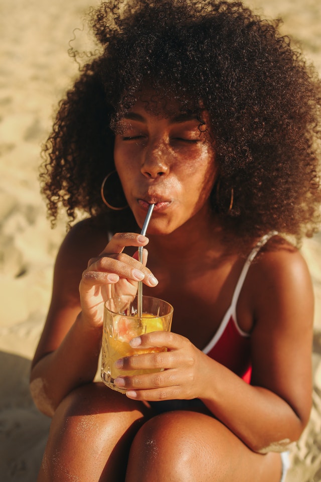 a lady drinking lemonade on a beach