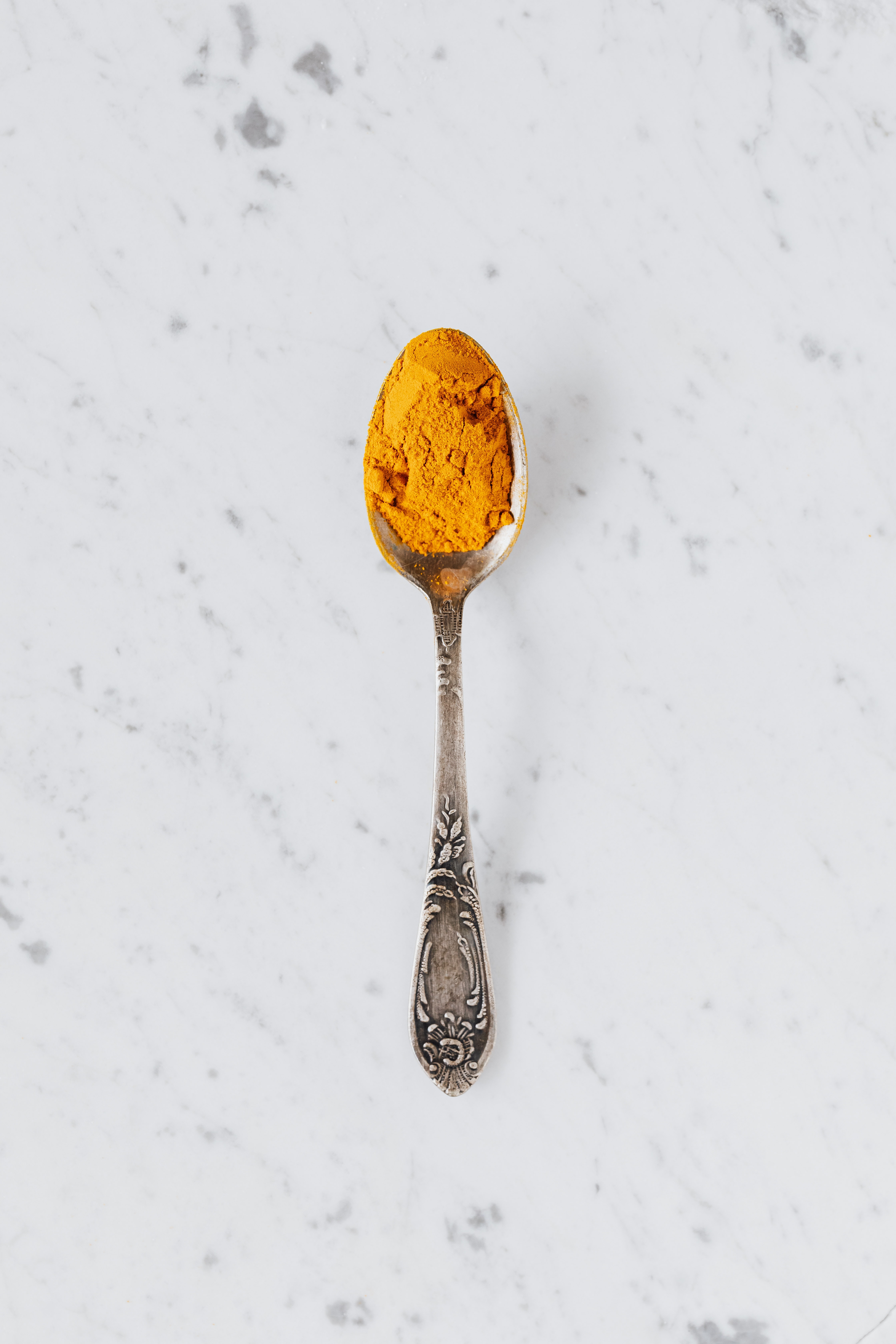 a teaspoon of turmeric on a white slab