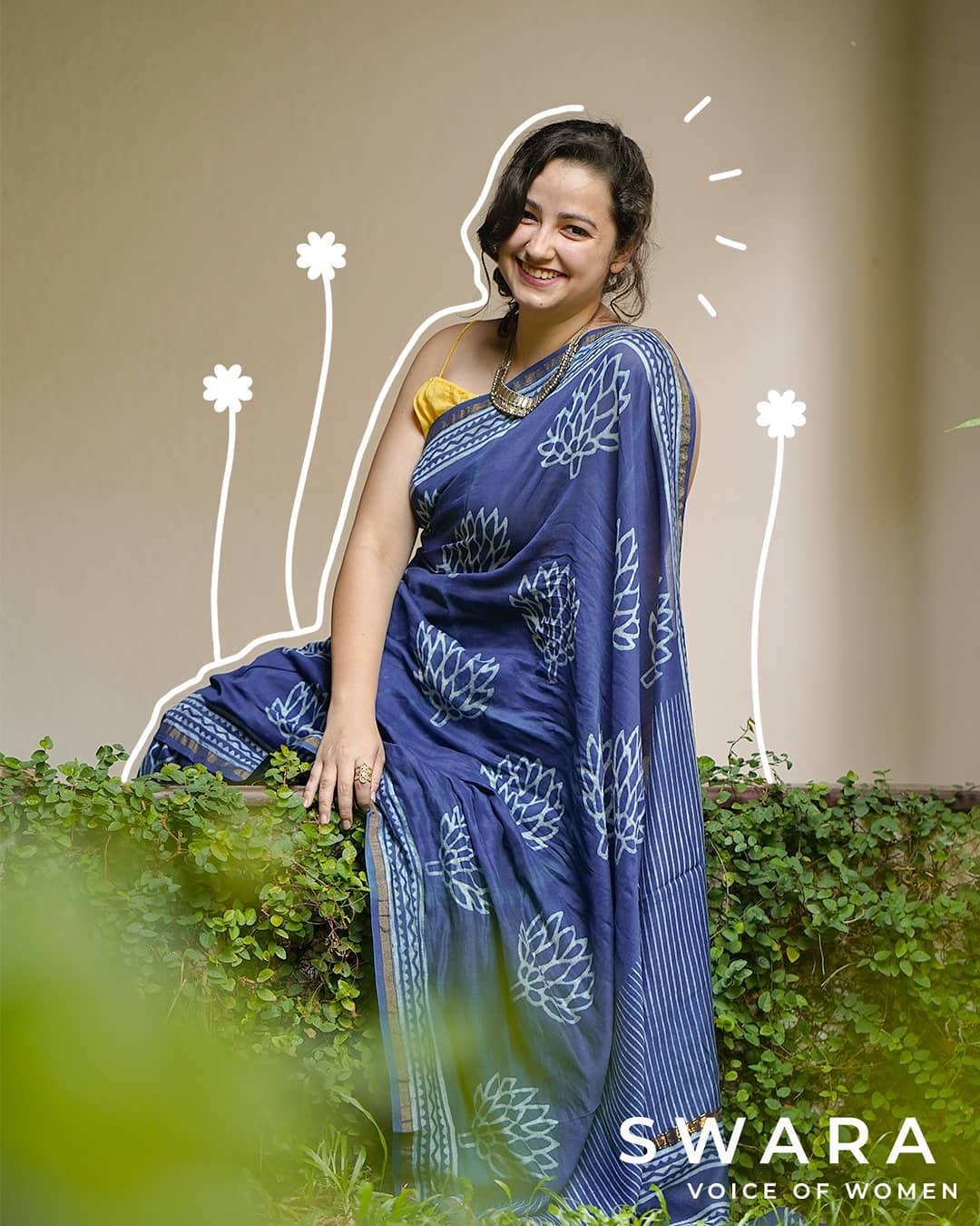 A woman wearing blue saree smiling
