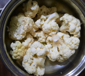 A container with roughly chopped cauliflower