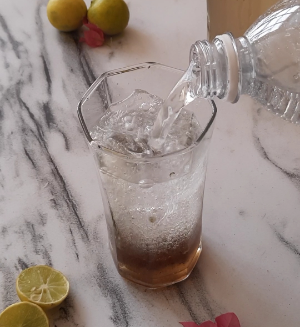 Sparkling water in a glass with kala khata syrup