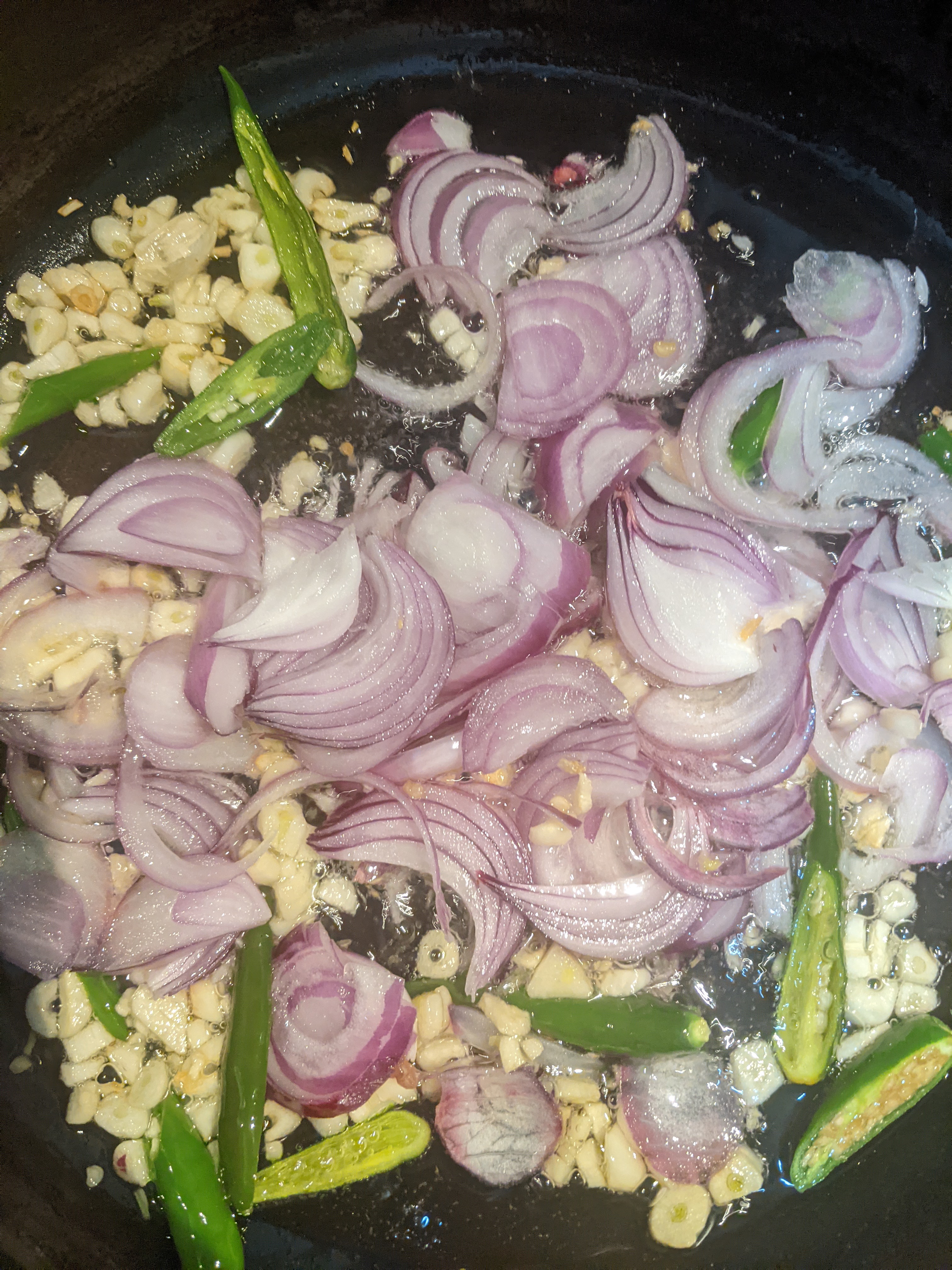 onions and green chillies added to the garlic in pan