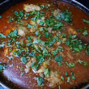 adding coriander to dhaba style chicken curry