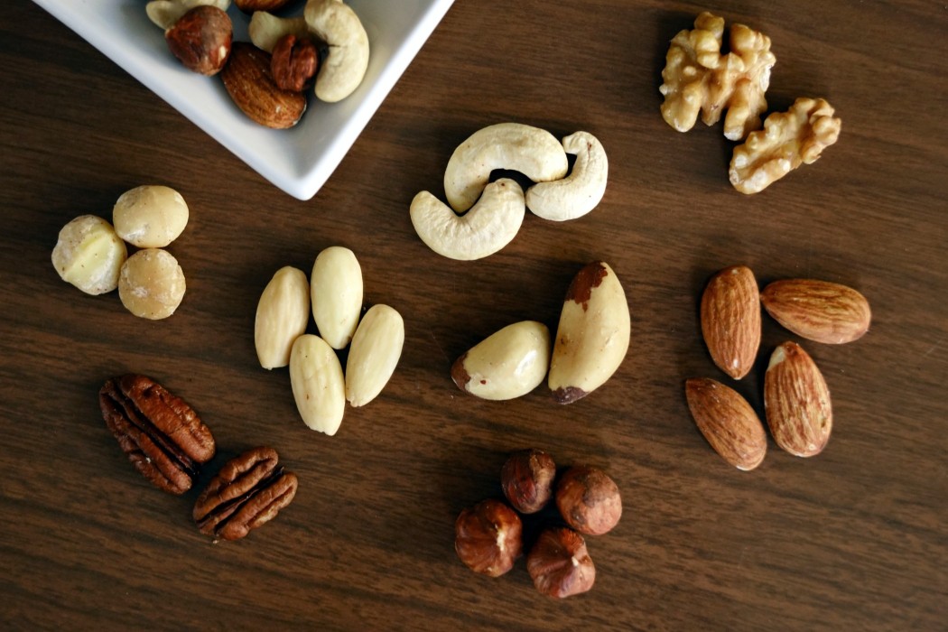 almonds, pecan nuts and macadamia nuts on a table