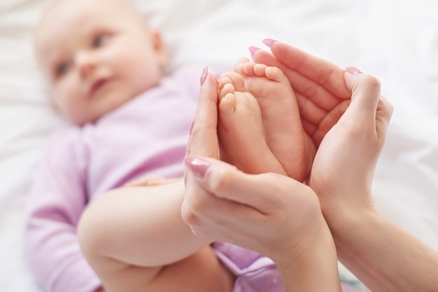 a new mom holding her infant's feet