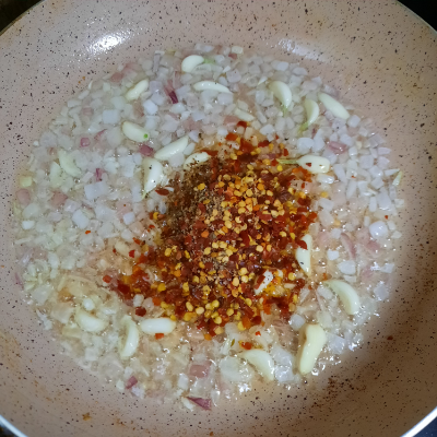 Add chilly flakes in onion garlic saute