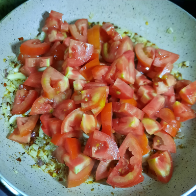 Add tomato in onion, garlic and chilly flakes saute